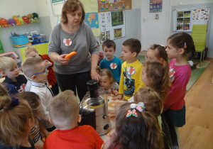 Nauczycielka wykonuje sok z dziećmi